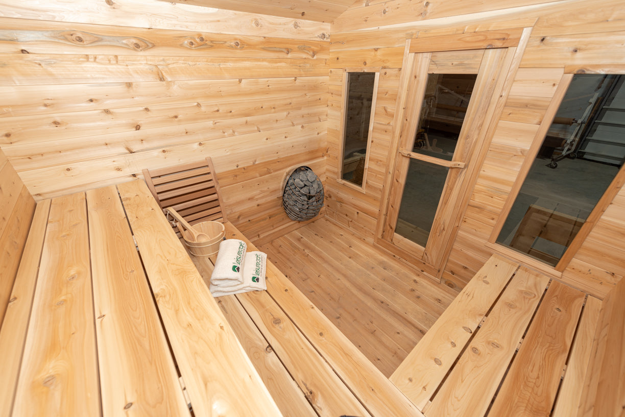 Wooden sauna interior with benches, towels, and a basket.