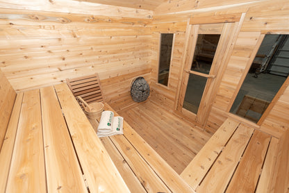 Wooden sauna interior with benches, towels, and a basket.