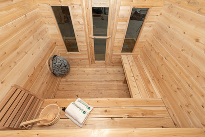 Wooden sauna interior with a bench, basket, and towel.