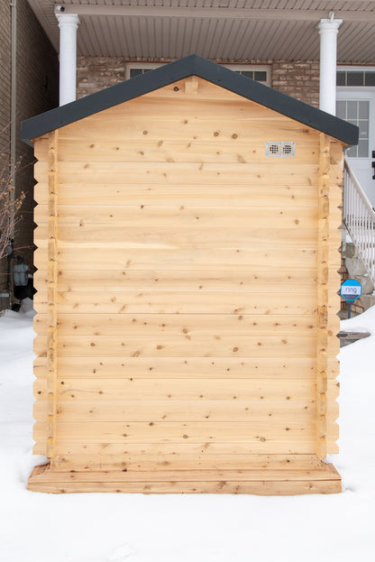 Wooden shed with a dark roof in front of a house