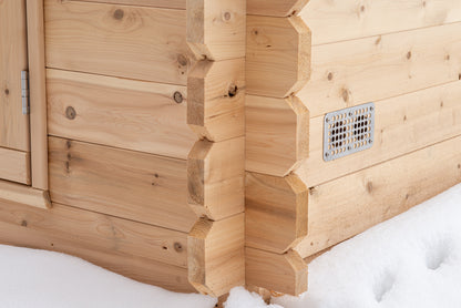 Wooden sauna exterior with snow on the ground