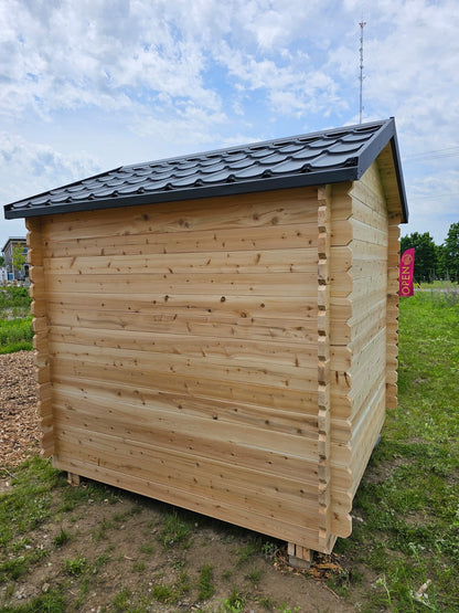 Wooden shed with a black roof in an outdoor setting