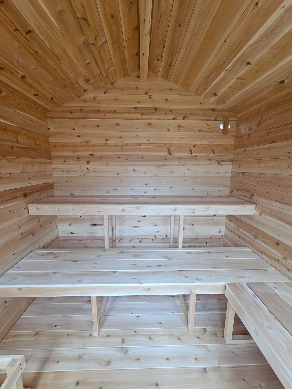 Wooden interior of a structure with benches and ceiling