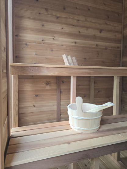 Wooden shelf with a bucket and ladle inside a wooden structure