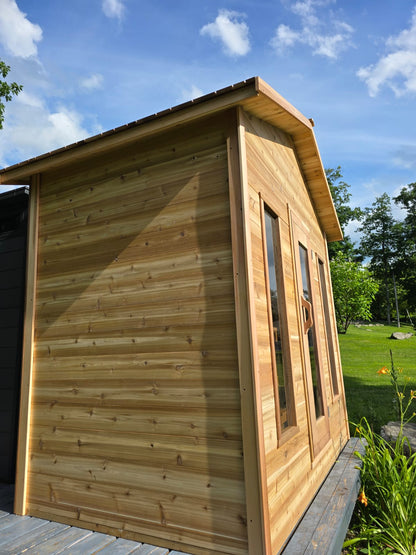 Wooden cabin with a grassy area and trees in the background