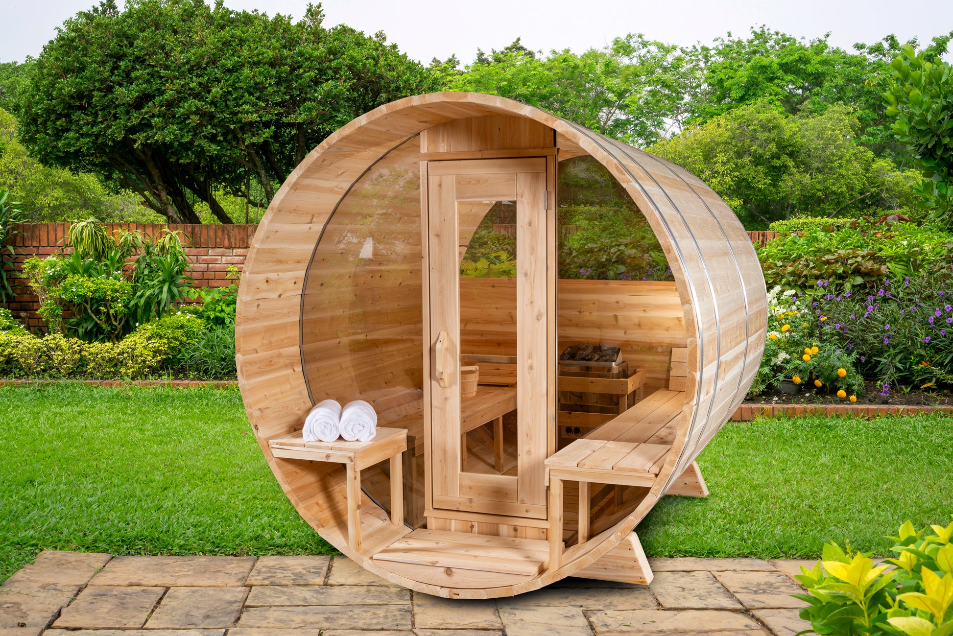 Wooden outdoor sauna in a garden setting with greenery.