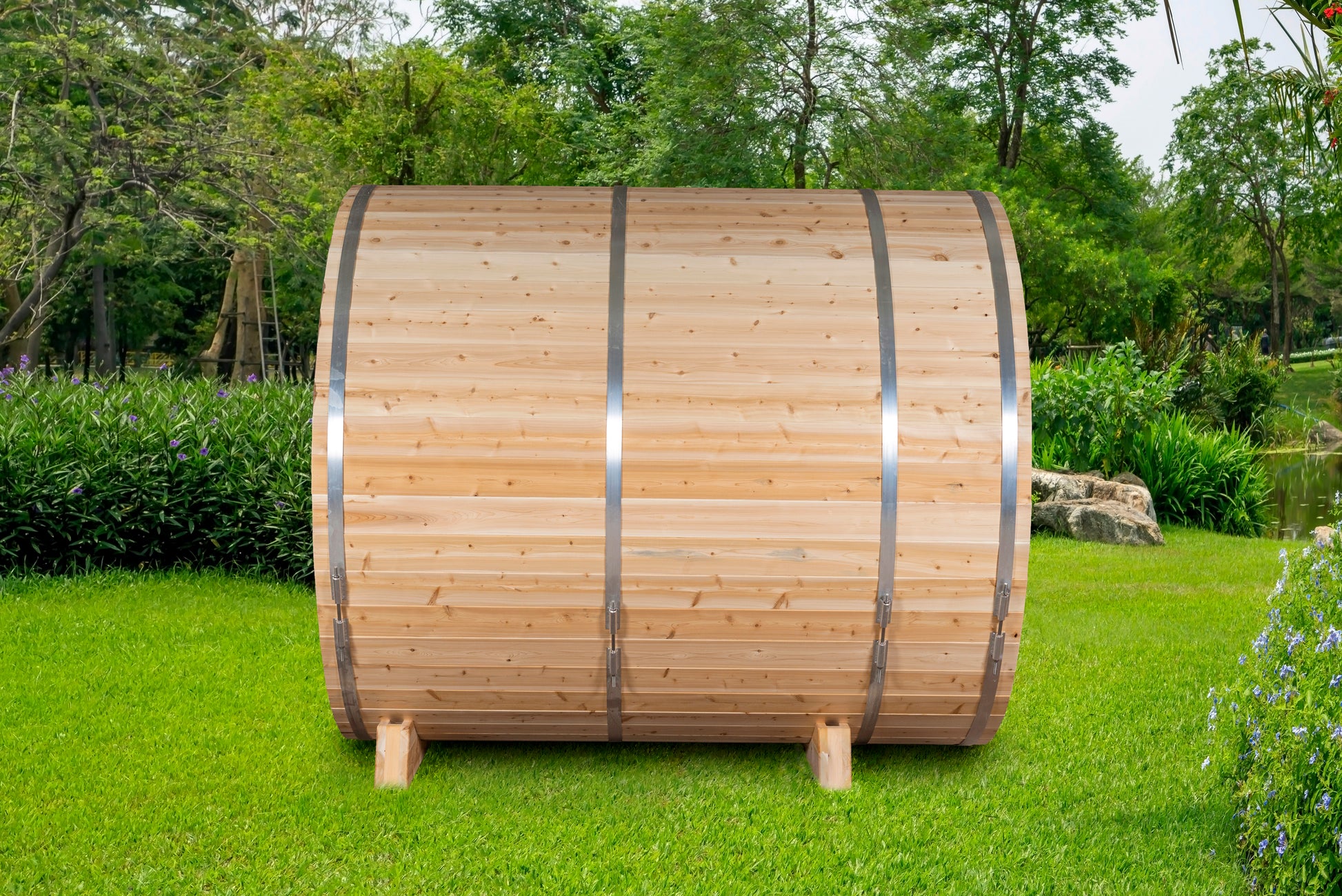 Wooden barrel-like structure on grass with trees in the background